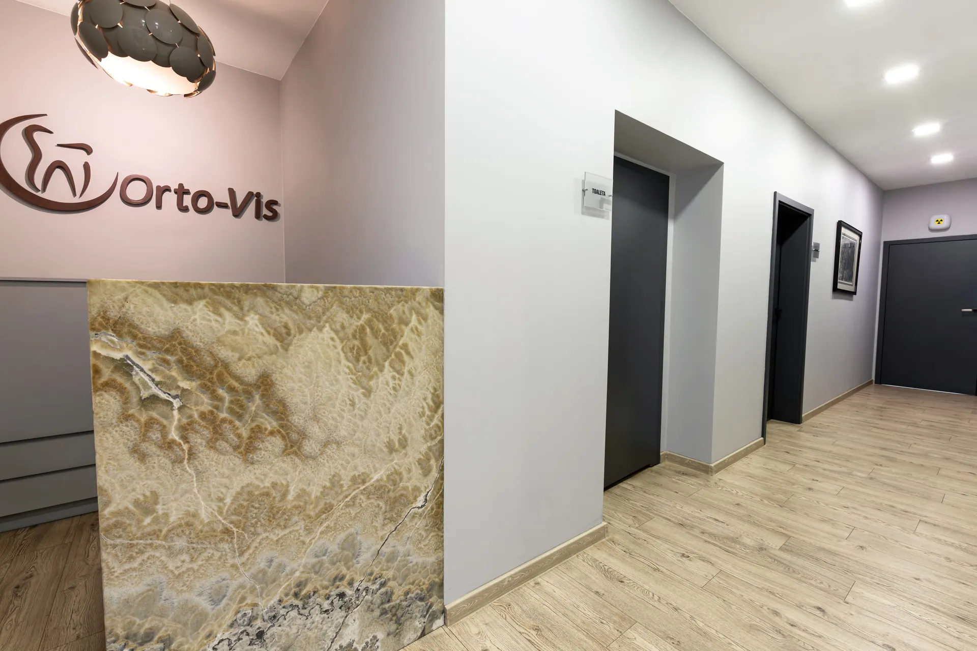 Orto-vis reception with the logo and stone counter at Kościuszki 48, Łódź.